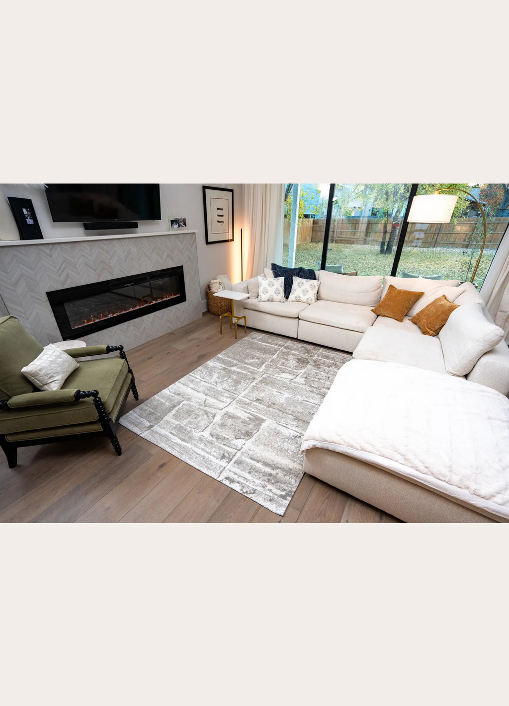Modern living room with a sectional sofa, armchair, and fireplace.